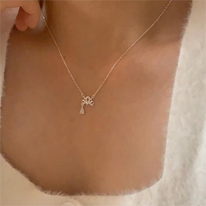 Detail of a gold crown pendant necklace with ribbon design and teardrop crystal