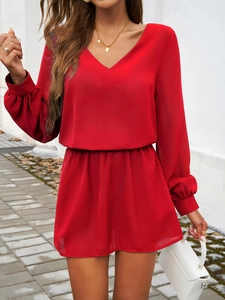 Détail de la robe courte rouge à col en V avec manches bouffantes et taille ceinturée