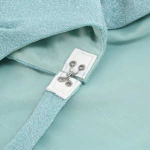 Close-up of mint green shimmering fabric with a metallic silver hook closure on the dress