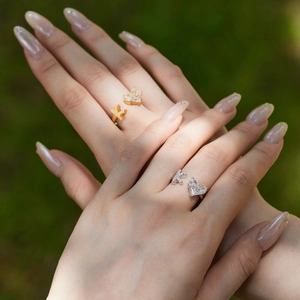 Close-up of S925 sterling silver heart and bow rings with zircon stones on fingers