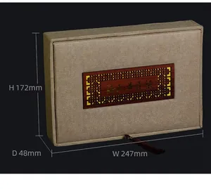 Macro view of Chinese style fabric gift box with carved wood plaque and tassel
