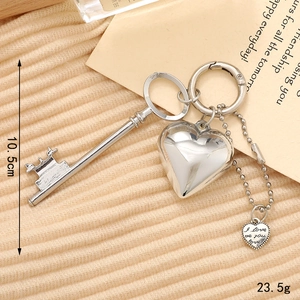 Silver vintage heart keychain with crown key pendant on a soft knit background