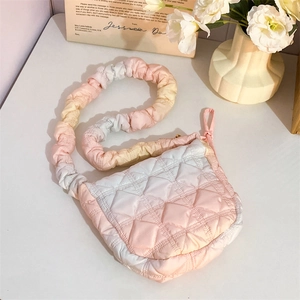 Detail of pink gradient puffer bag featuring quilted rhombic texture and ruffled cloud strap