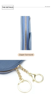 Detail of blue pebble leather coin purse with golden zipper and sturdy metal keychain