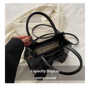 Internal view of black bow tote bag showing large capacity and interior zipper pocket