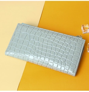 Top view of blue-grey long wallet with crocodile pattern and zipper detail