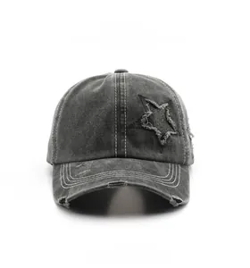 Detailed view of gray washed cotton baseball cap with star patch and distressed embroidery