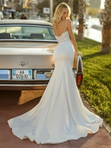 Exquisite lace lace-up back and long satin fish tail on a white minimalist bridal gown