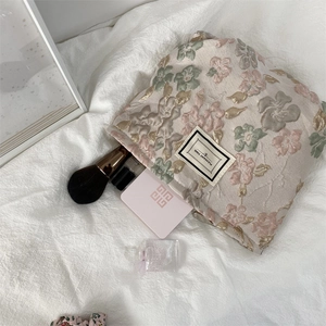 Détail de la trousse de maquillage en jacquard brodé avec étiquette Pleasant Time