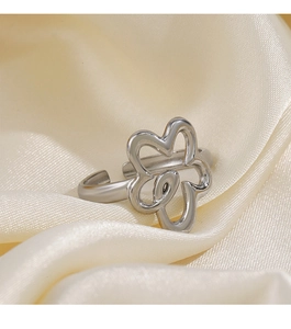Macro shot of silver hollow flower ring on soft beige silk background with detail focus