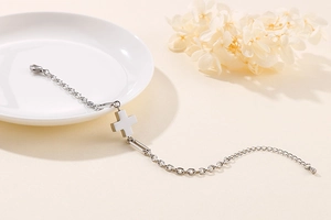 Detail of silver stainless steel chain bracelet with cross pendant and lobster clasp