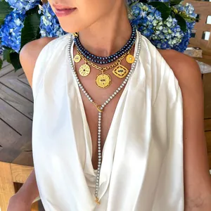 Collier multicouche en or avec pendentif mauvais œil et perles porté par mannequin