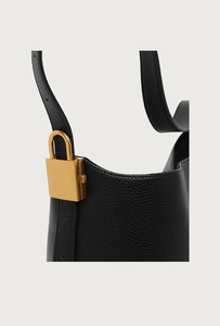 Detail der schwarzen Hobo-Tasche aus genarbtem Leder mit goldenem Metall-Vorhängeschloss