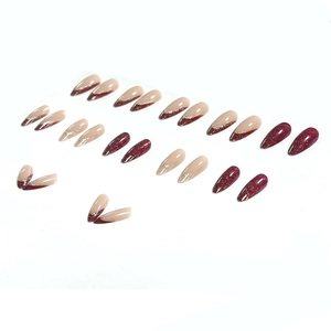 Almond-shaped press-on nails with wine red French tips and gold glitter accents