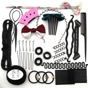 Flat lay of professional hair styling tools including plastic needles and sponge bun maker