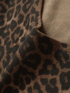 Macro shot of fine knit leopard print fabric showing soft texture and detailed stitches