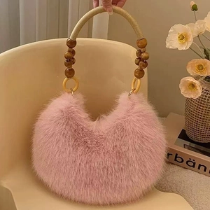 Detailed texture of pink faux fur handbag with wooden bead and gold woven handle