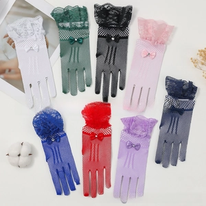 Flat lay of colorful fishnet bridal gloves with lace trim and beaded bow details