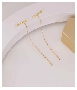 Detailed view of minimalist gold tassel ear lines with slim chain and bar in 18k plating