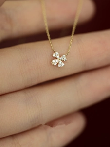 Macro shot of 925 silver 14k gold four-leaf clover pendant with pavé set diamonds