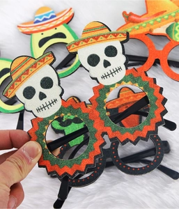 Close-up of Mexico festival party glasses featuring glittery skull and sombrero patterns
