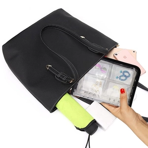 Spacious interior of black lychee grain tote bag holding jewelry book and umbrella