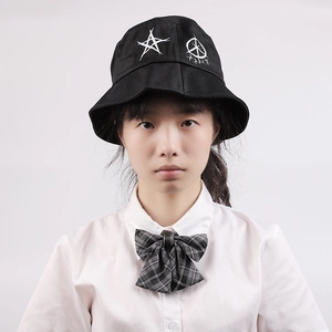 Front view of black fisherman hat with white star embroidery worn by person in white shirt