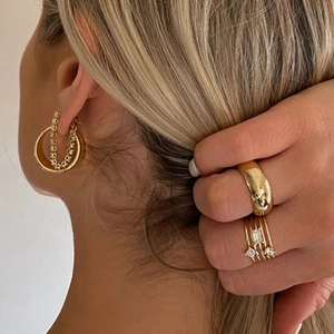 Close-up of a model wearing S925 silver chain earrings and stacked gold cubic zirconia rings
