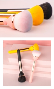 Detail of soft gradient makeup brushes with gold trim and fluffy synthetic bristles