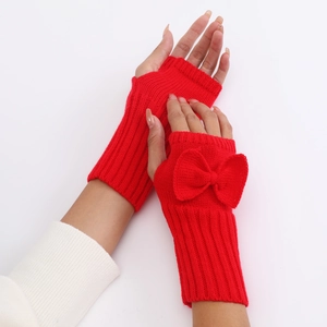 Detail of red knit fingerless gloves featuring a cute bow and cozy wrist warmers