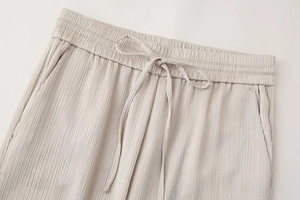 Detalle de pantalones plisados ligeros con cintura elástica y cordón a juego