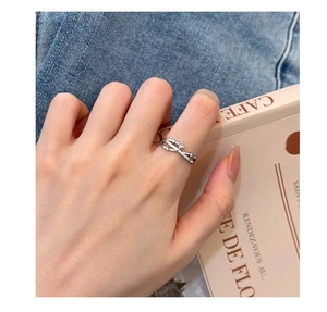 Close-up of lifestyle view showing a silver crisscross ring with zircons on a model hand