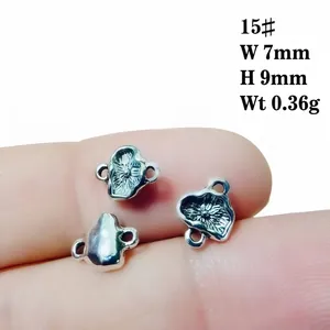 Close-up of small silver alloy lotus pendant for DIY jewelry showing 7x9mm dimensions