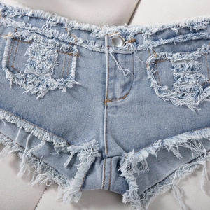 Dettaglio dell'orlo sfrangiato e della trama denim degli shorts sexy blu chiaro