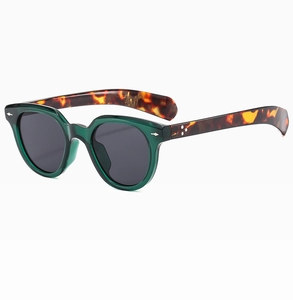 Detail of vintage oval sunglasses with translucent green frame and tortoiseshell temples