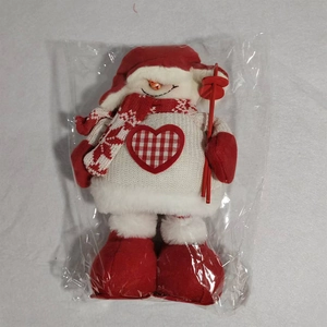 Detailed view of plush Christmas snowman doll with heart pattern in clear packaging