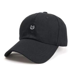 Close-up of the detailed white cat embroidery on a black cotton baseball cap