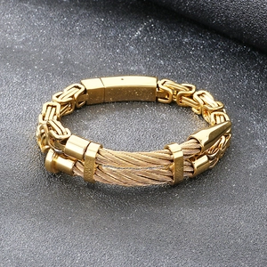 Macro shot of gold double-row industrial punk bracelet with steel wire and Byzantine chain