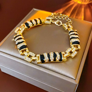 Detail of a gold-plated link bracelet with leopard print and crystals on a jewelry box
