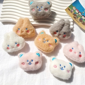 Detailed overhead shot of colorful plush animal brooches in various cute embroidery styles