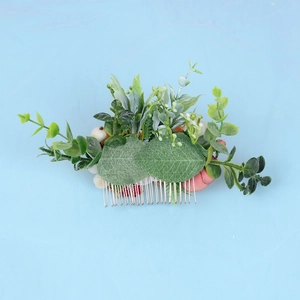 Detailed shot of handmade floral hair comb with realistic leaves and berries for bridal hair