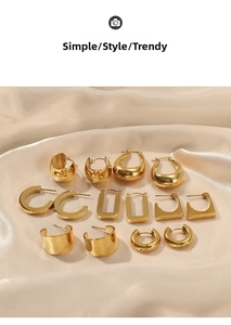 Close-up of assorted geometric 14K gold plated stainless steel earrings on silk texture