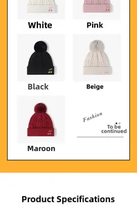 Close-up of winter knitted beanies featuring cherry embroidery and soft fur pom-poms