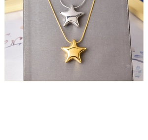 Close-up of polished star pendant necklaces in gold and silver on a display board