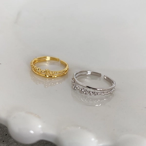 Detail of gold and silver S925 rings with irregular bubble texture and open band design
