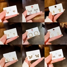 Detailed close-up of S925 silver stud earrings set with heart and butterfly motifs