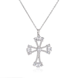 Macro shot of silver cross pendant with micro-pave zircons and oval gemstones
