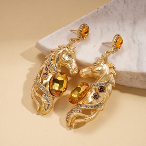 Macro view of horse head earrings with amber crystals and gold metal detailing
