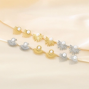 Vue détaillée des boucles d'oreilles perles soleil en or et argent sur satin