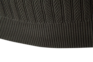 Macro view of olive green knit sweater featuring herringbone texture and ribbed hem